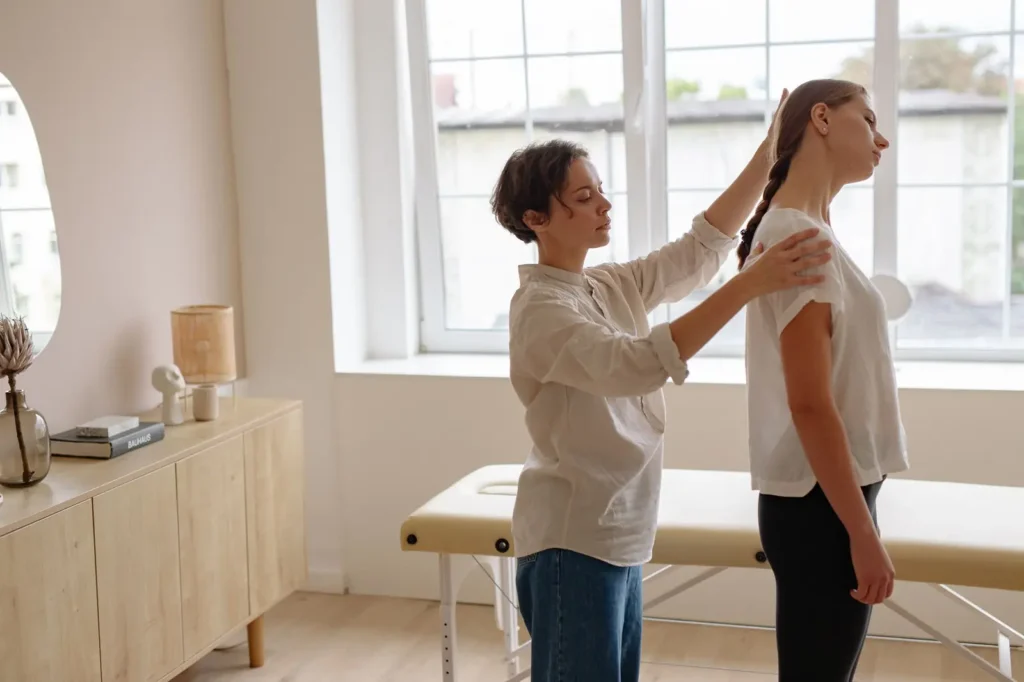 Chiropractor checking a patient's posture in a bright clinic