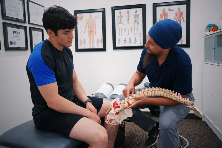Chiropractor explaining a spine model to a patient