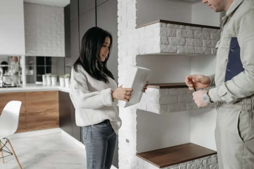 Homeowner reviewing a plan with a service technician in her kitchen