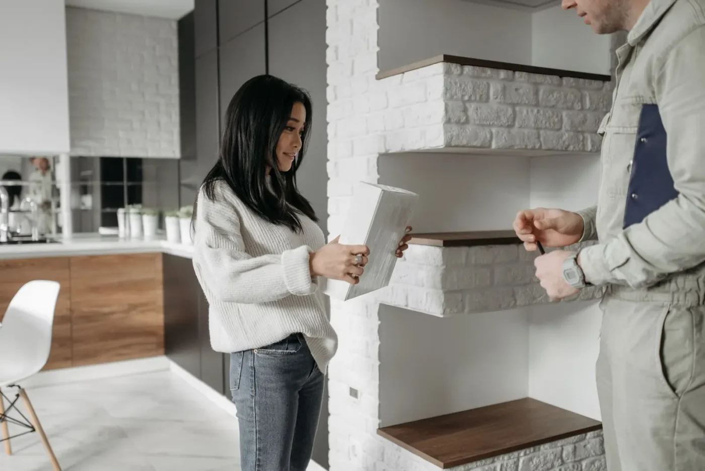 Homeowner reviewing a plan with a service technician in her kitchen
