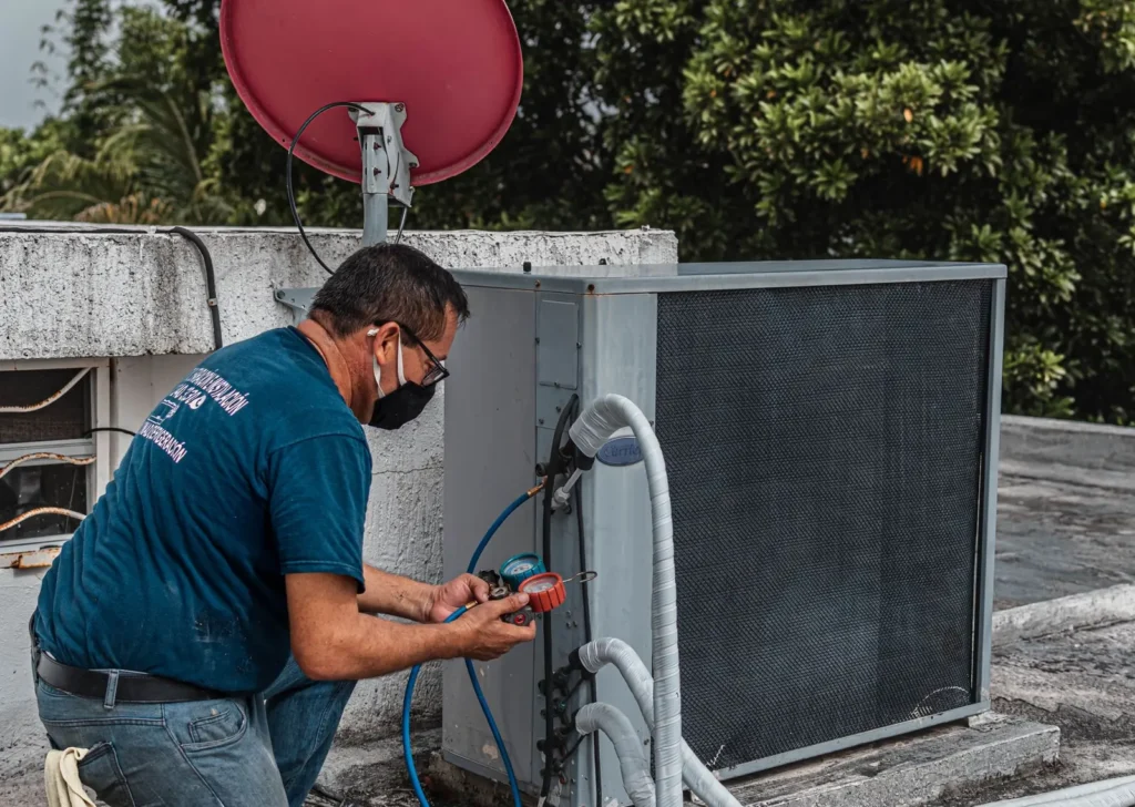 Technician checking an air conditioning unit with a gauge