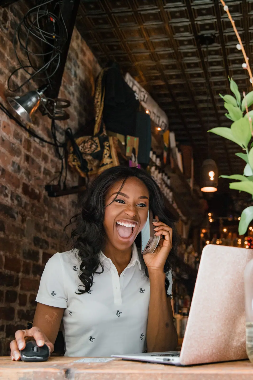 Small business owner laughing on a phone call at her laptop