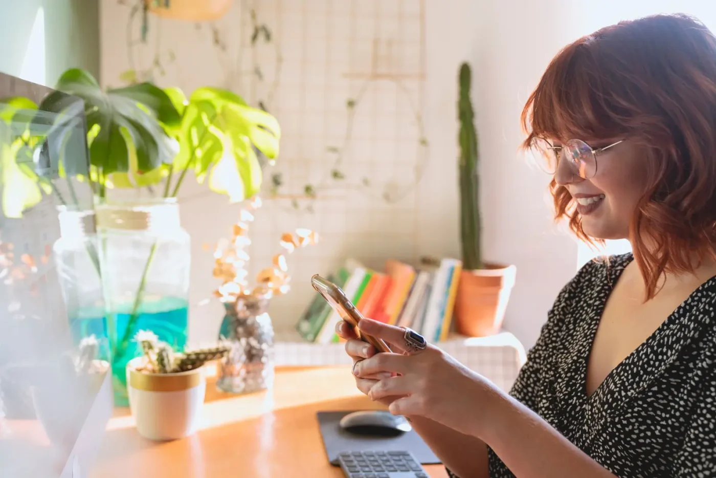 Woman smiling while reading on her phone at home