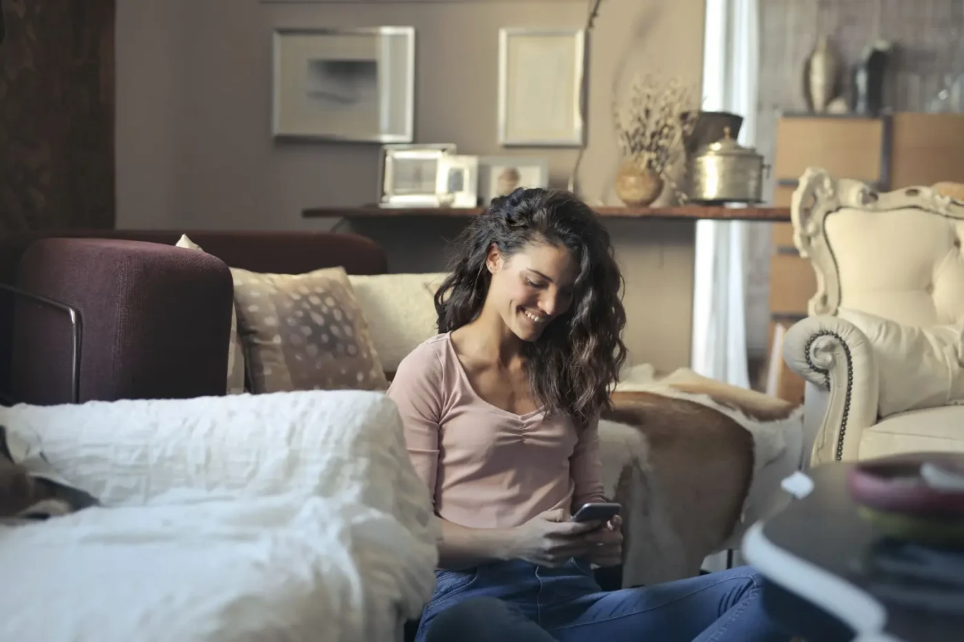 Woman using her phone on a living room sofa