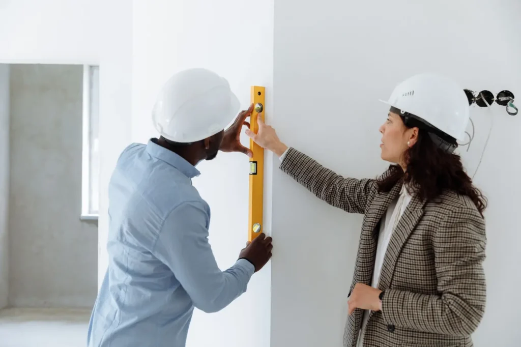 Contractors checking a wall with a level