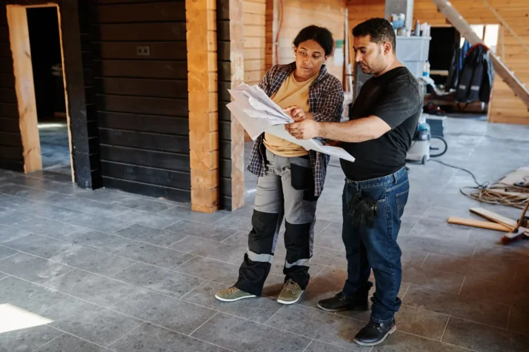 Contractors reviewing plans inside a home under renovation
